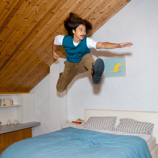 Persoon springt energiek op bed